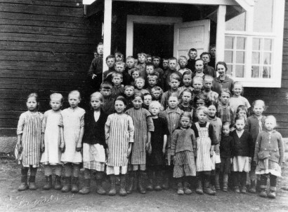 En skolklass med sin lärare utanför skolan i Kainulasjärvi, Tärendö, 1920-tal. Nordiska museets bildarkiv.